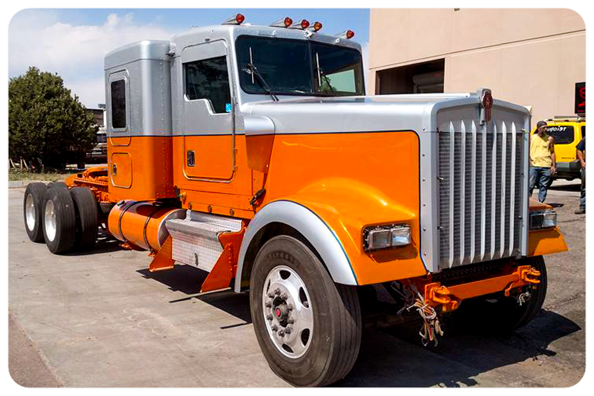 Peterbilt semi truck side view showing orange and silver paint